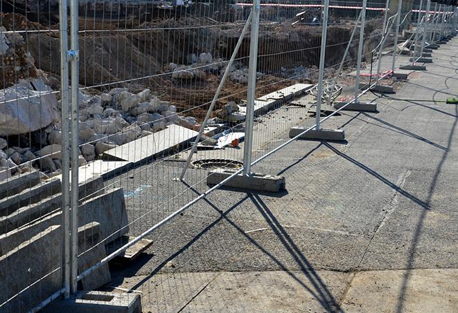 a temporary fence panel installation that helps to prevent debris from getting out of the job site